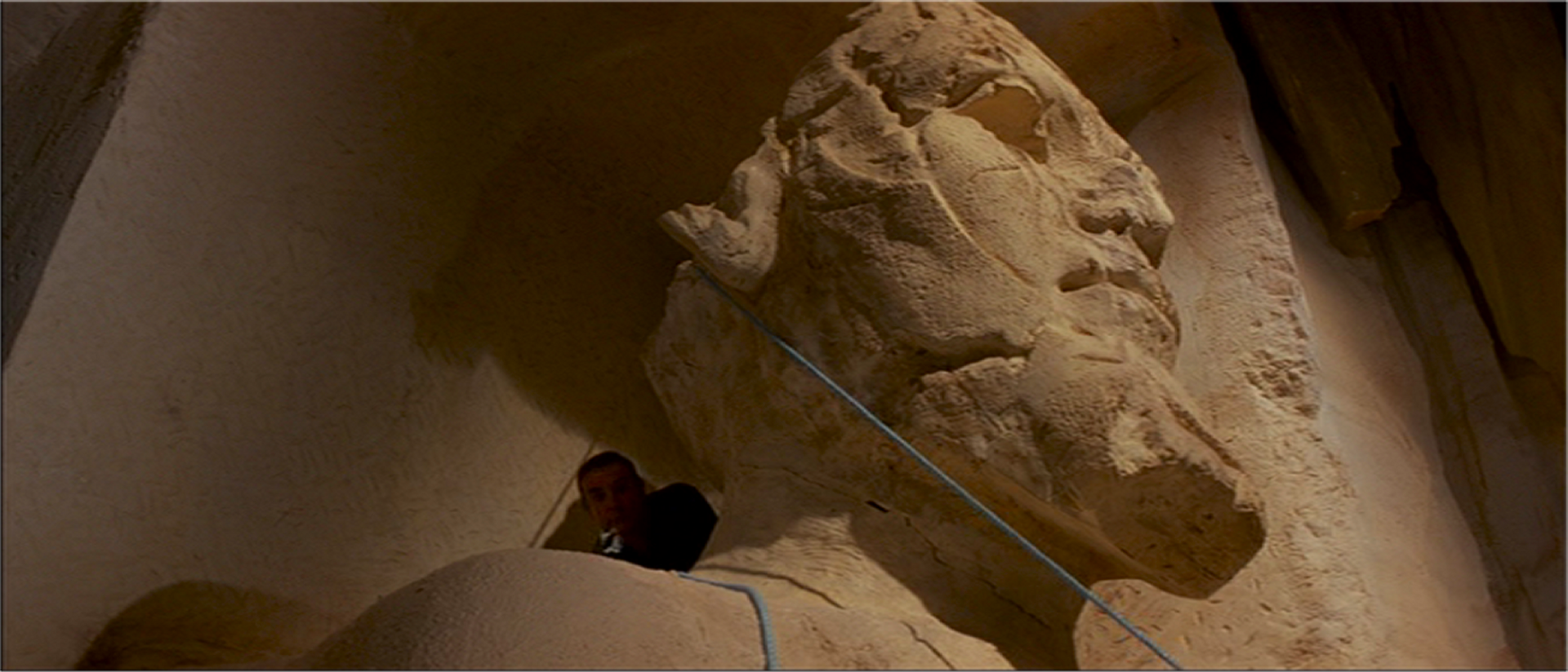 Bond hides behind the Colossus Head and plans next move.