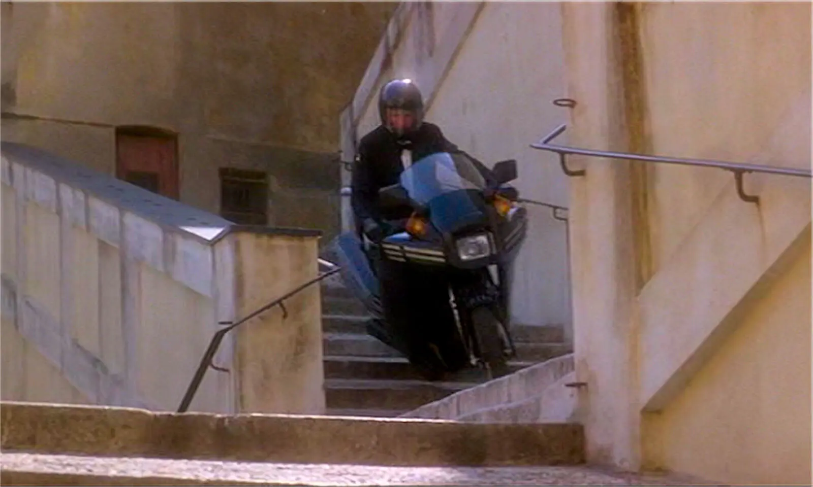 Bond on motor bike on stairs in pursuit of Fatima Blush.